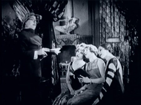 Bess’s friends make fun of Jack. That’s Julia Faye on the end with the amazing spiral sleeve gown.